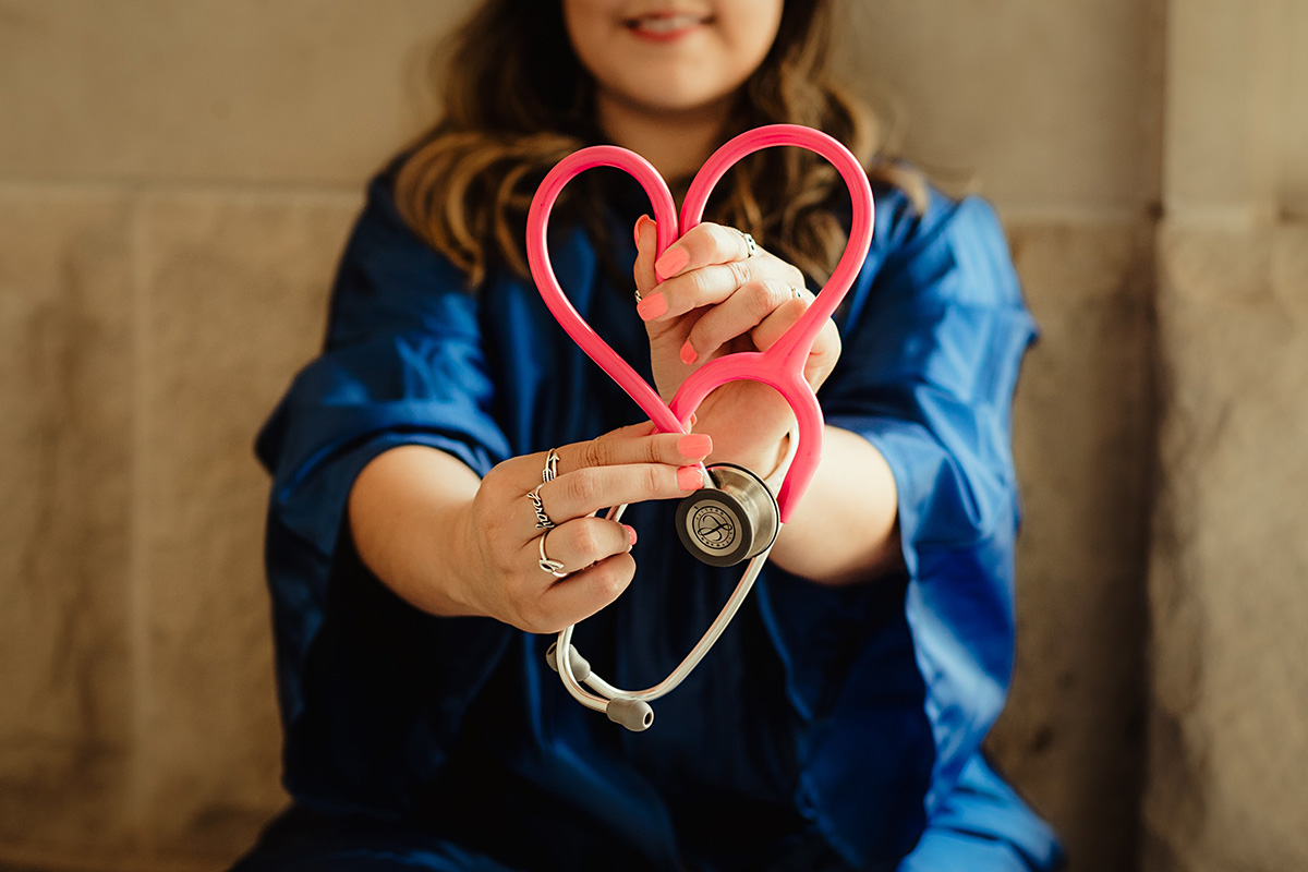 Student engaged in CNA training showing stethoscope cord in the shape of a heart.